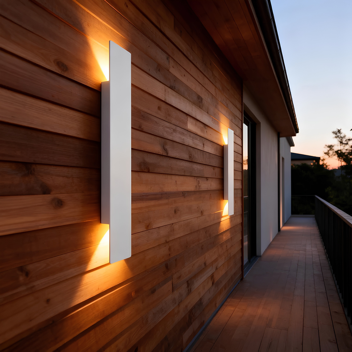 Matte black IP65 up/down wall pillar lights casting a warm ambient glow on a cedar timber exterior wall at dusk.