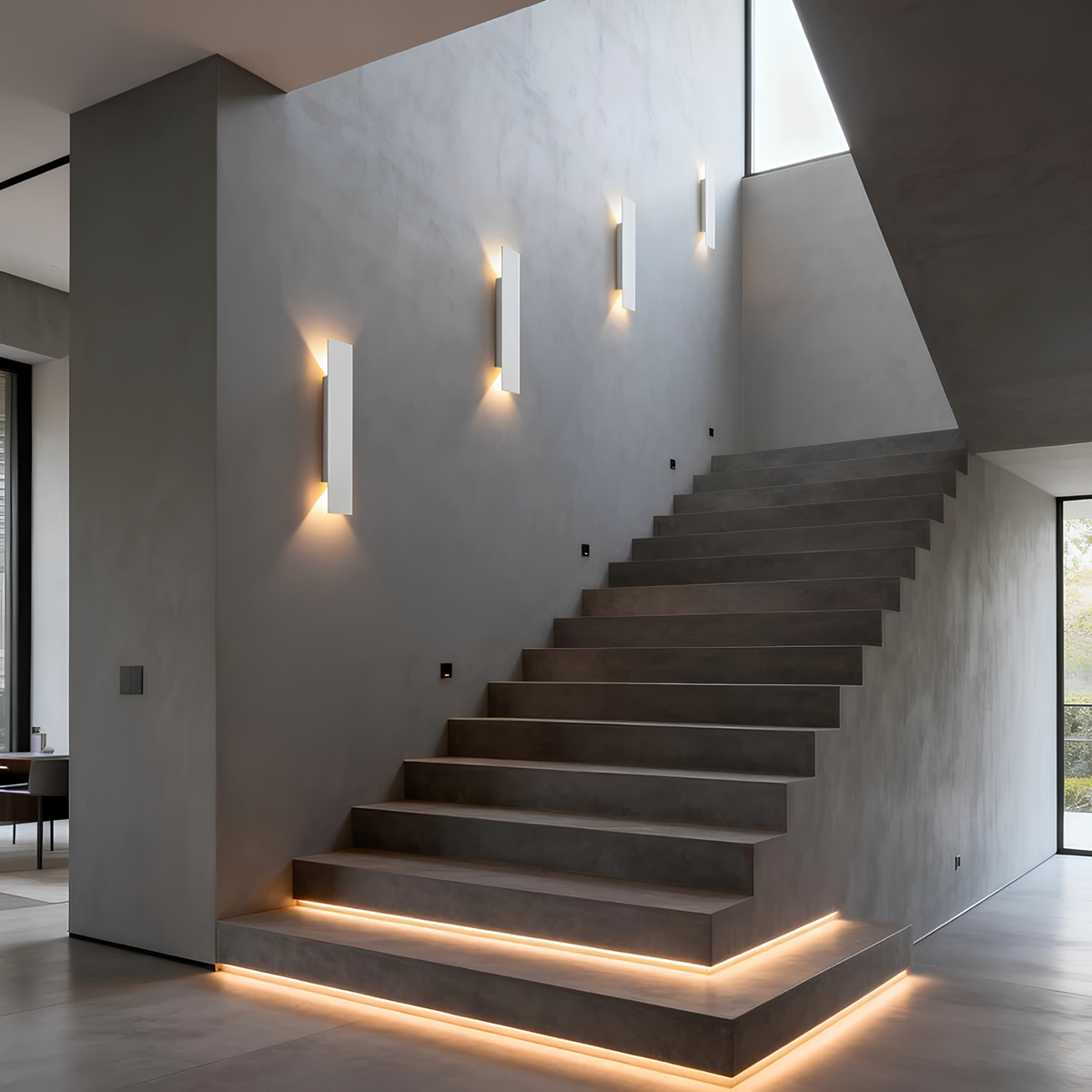 Matte black IP65 up/down wall pillar lights illuminating a stepped exterior staircase and rendered wall at dusk.