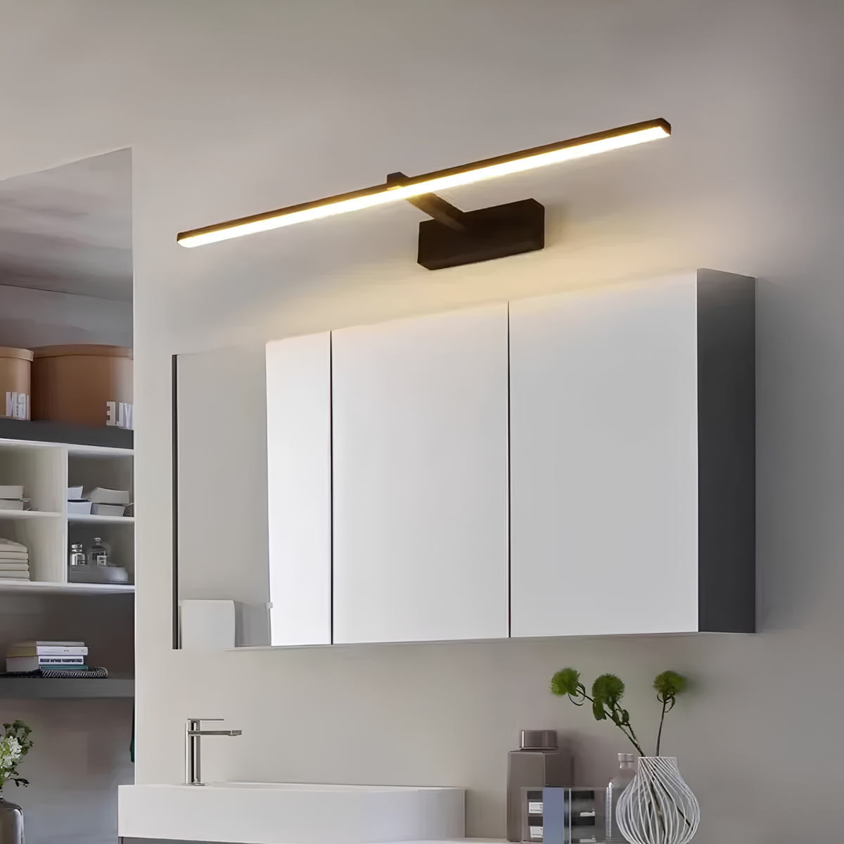 Matte black LED vanity bar light mounted above a mirrored medicine cabinet in a warm-toned bathroom.